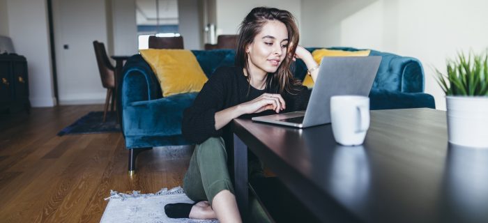 A young woman is using a laptop at home.